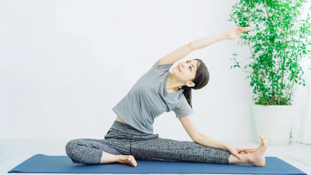 座って体側伸ばしをする女性